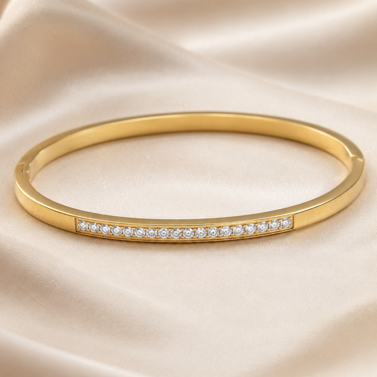 Golden Starlight Zircon gold bangle bracelet displayed on champagne satin