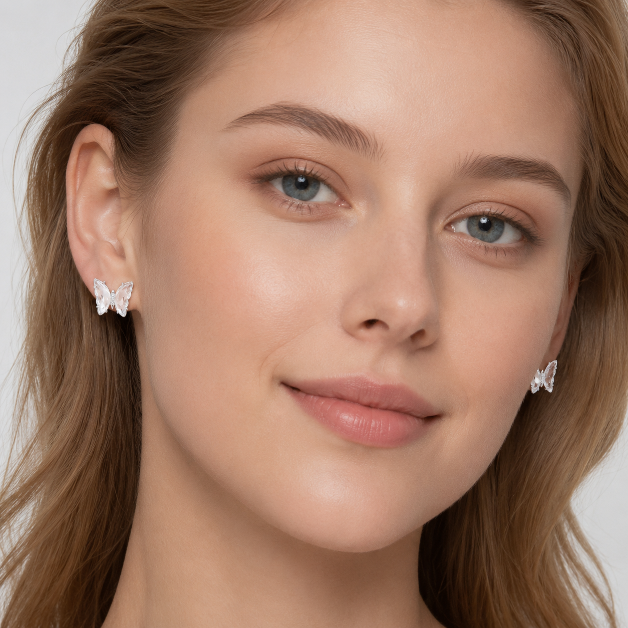Woman wearing delicate butterfly zircon stud earrings